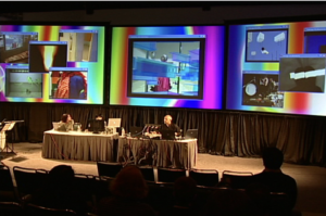 “Loose Minds in A Box” at SIGGRAPH 2005. Miho Aoki (left) performing locally and Jimmy Miklavic (right) directing and mixing in real-time over 15 Internet-2 streams from multiple Access Grid sites, across North America. Photo courtesy of Another Language Performing Arts.